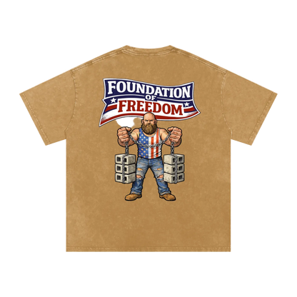 Beige t-shirt with a graphic of a man in chains wearing an American flag shirt and 'Foundation of Freedom' text on a white background.