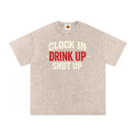 Beige t-shirt with text 'Clock In Drink Up Shut Up' on a white background